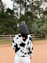 Sweater de tejido de punto con diseño de manchas en contraste, cuello redondo y mangas largas. Presenta un calce cómodo y holgado.