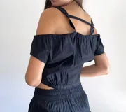 Conjunto de dos piezas compuesto por una musculosa de hombros caídos con detalles en color champán y un short con cintura elástica a juego. Confeccionado en tela con acabado satinado.