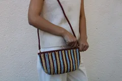 Cartera tipo sobre confeccionada en cuero trenzado a mano, con diseño de rayas verticales en tonos negro y natural.