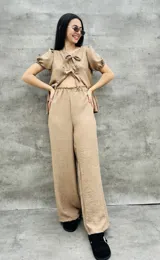 Pantalón palazzo color beige de tiro alto con elástico en la cintura.