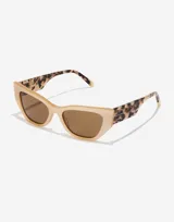 Gafas de sol Hawkers modelo Manhattan, con montura color beige y patillas con estampado animal print.