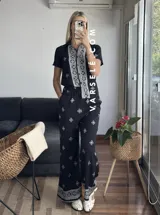 Conjunto de camisa de manga corta con cuello y pantalón largo de corte palazzo, ambos con estampado geométrico en blanco y negro.