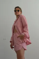 Camisa a rayas rojas y blancas de manga larga, con cuello clásico y corte holgado.