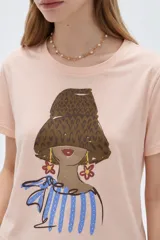 Remera de algodón de manga corta, color blanco, con cuello redondo y estampado frontal ilustrado con una mujer de perfil.