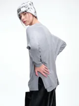 Sweater de punto color gris, con escote en V profundo, hombros caídos y diseño holgado de corte relajado.