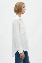 Camisa de seda negra de corte holgado, con cuello camisero y escote en V, cierre frontal con botones y dos bolsillos en el pecho.
