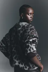 Buzo oversized de punto jacquard con estampado de leopardo, cuello redondo acanalado y hombros caídos. Presenta puños y bajo con terminación acanalada.