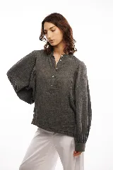 Camisa gris de algodón con textura natural, cuello mao con tapeta de botones, mangas largas abullonadas y puños amplios con botón.