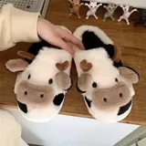 Pantuflas de peluche con diseño de vaca, confeccionadas en piel sintética suave. Cuentan con suela de goma antideslizante y diseño abierto en el talón.