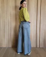 Pantalón de jean estilo wide leg con costuras verticales frontales, tiro alto y bolsillos laterales.