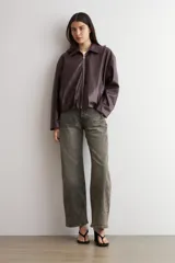Chaqueta bomber de eco cuero en color bordó, con cierre frontal metálico y cuello clásico. Presenta un diseño de corte recto y mangas largas.