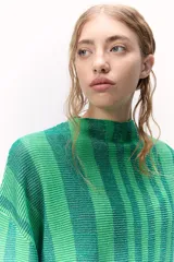 Sweater tejido de punto a rayas texturizado con lurex, color verde y azul. Cuenta con un calce oversize, mangas tres cuartos y cuello bote.