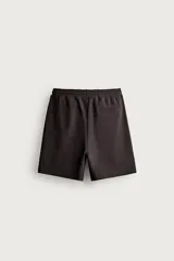 Bermuda estilo jogger de ajuste relajado, confeccionada en tejido interlock de algodón. Cuenta con cintura elástica ajustable con cordón, bolsillos frontales de vivo y diseño liso.