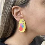 Par de aros de porcelana fría con forma ovalada y diseño abstracto con círculos de colores y strass.