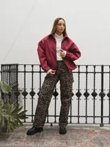 Campera gris con cierre frontal, cuello camisero y mangas largas con puños elásticos.