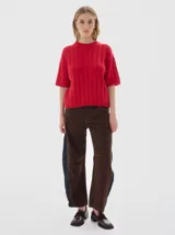 Buzo tejido de manga corta color rojo, con cuello redondo y diseño de punto acanalado y trenzado.