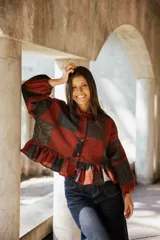 Kimono de lino con diseño patchwork en tonos rojizos y oscuros, con cuello camisero, cierre frontal de botones, mangas largas abullonadas y ruedo con volados.