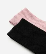 Kit de dos vinchas para el pelo confeccionadas en poliéster con textura acanalada, en color negro y rosado.