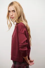 Buzo de punto color beige, con cuello redondo y manga larga.