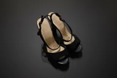 Sandalias de fiesta color negro con plataforma y taco alto cuadrado. Presentan tiras cruzadas en el empeine con acabado brillante y cierre de pulsera con hebilla metálica.