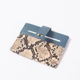 Tarjetero celeste y con estampado animal print de serpiente, con ranuras para tarjetas y tira con botón a presión.
