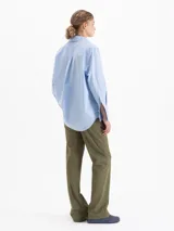 Pantalón de corte recto confeccionado en tela sastrera, con cintura de cuero vacuno, raya marcada en el centro de las piernas y bolsillos laterales.
