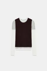 Camiseta de manga larga con diseño de capas superpuestas que crea un efecto triple. Presenta cuello redondo, corte ajustado y combinación de colores en tonos blanco, gris y negro.