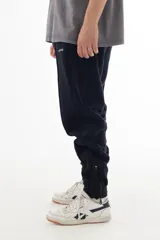 Pantalón de jogging azul marino de algodón grueso con interior cálido, corte amplio, tiro medio, cintura elástica con cordón, cierres en los tobillos y logo "vernal" bordado en la pierna izquierda.