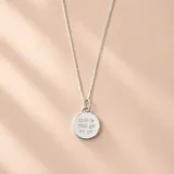 Conjunto de collar y dije de plata con cadena de eslabones y medalla redonda grabada con datos de nacimiento.