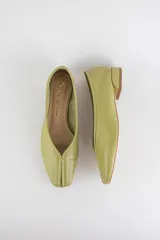 Mocasín de cuero color verde oliva, con costura central en la capellada y punta cuadrada. Cuenta con taco bajo cuadrado.