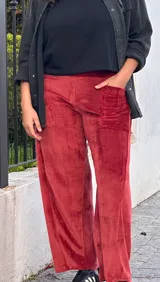 Pantalon de corte barrel en plush de algodon color bordó, con tiro medio, bolsillos frontales y traseros, y faja ancha en la cintura.