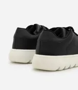 Championes Viko de diseño minimalista con acabado liso, capellada de poliuretano color negro, cordones al tono y suela bold volumosa de color blanco.