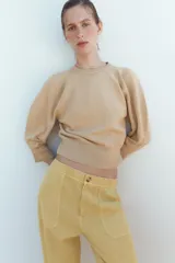 Jersey de punto color amarillo claro, con cuello redondo y mangas abullonadas.