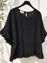 Blusa negra de tela liviana y fresca con textura sutil, corte holgado, mangas cortas con volados y detalles de volados en el ruedo. Presenta escote redondo con pequeña abertura y botón en la espalda.