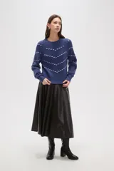 Sweater de punto color azul con diseño de fantasía en forma de líneas curvas punteadas en color celeste. Presenta cuello redondo a la base, mangas largas con puños acanalados y corte holgado.