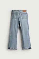 Jeans flare fit de denim negro, tiro medio, ajustados arriba y con botamanga acampanada. Cuentan con cinco bolsillos, lavado efecto gastado y bajo con acabado irregular. Cierre frontal con cremallera y botón.