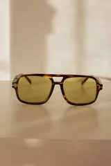 Lentes de sol tipo aviador retro con diseño cuadrado y oversize, armazón carey y detalles metálicos en las bisagras.
