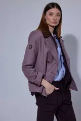 Chaqueta de paño con doble abotonadura, botones de cuero y cuello de piel sintética. Presenta un diseño de largo a la cadera con bolsillos verticales delanteros y forro interior.
