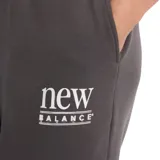 Pantalón de jogging New Balance de corte ancho y tiro alto, color gris oscuro, con cintura elástica y logo de la marca estampado en blanco en la pierna izquierda.