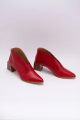 Botines de cuero color beige con diseño de tajo frontal, punta fina y taco cuadrado de madera.