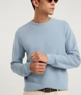Suéter de punto para hombre, color celeste, con textura acanalada horizontal, cuello redondo y mangas largas con puños ajustados.
