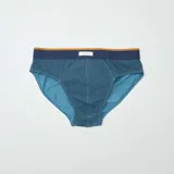 Pack de tres slips de hombre, uno azul marino con estampado geométrico, uno azul liso y uno azul con rayas horizontales y estampado geométrico.