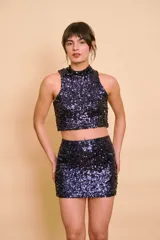 Top corto sin mangas con cuello alto, confeccionado completamente con lentejuelas brillantes en tono azul marino.