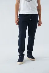 Pantalón deportivo de invierno, corte clásico con bolsillos laterales y cintura elástica con cordón ajustable. Presenta logo estampado y detalle en goma.