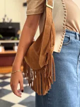 Cartera bandolera de cuero color camel con flecos largos en la parte inferior.