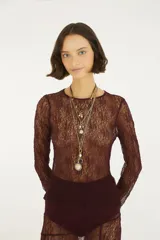 Top de encaje color bordó con escote redondo y mangas largas, de diseño transparente y ajustado.