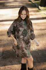 Vestido corto de lino con estampado floral en tonos tierra, verde y marrón. Presenta cuello redondo, mangas tres cuartos con volumen y silueta holgada.