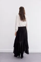 Falda larga de viscosa chiffon color negro, con diseño amplio y voluminoso. Presenta un ruedo irregular con volados que aportan movimiento y cintura elastizada para mayor comodidad. Incluye forrería interna a tono.