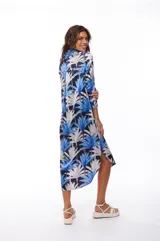 Vestido camisero midi con estampado de hojas de palmera en tonos azul, blanco y negro. Tiene cuello camisero, mangas largas con puños abotonados, cierre frontal con botones y bolsillos laterales.
