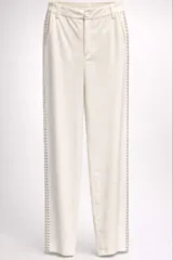 Pantalón sastrero de corte recto y cintura media con elástico en la parte posterior. Presenta una banda lateral decorativa con pedrería brillante a lo largo de ambas piernas, bolsillos laterales y cierre frontal con botón.